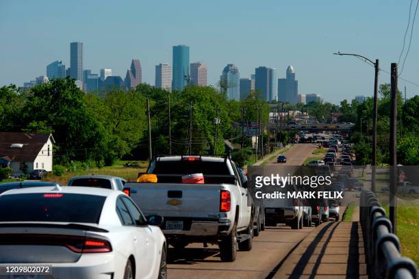 Cars are lined up in traffic on Airline Drive after a food distribution site at Reyes Produce opened on April 13, 2020 in Houston, Texas. - While...