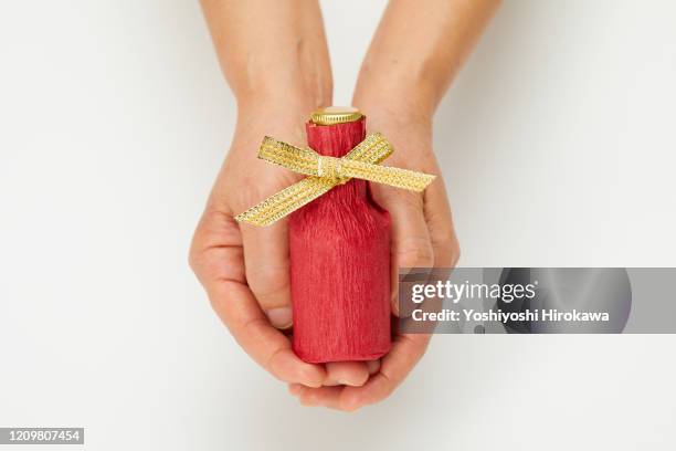 holding wrapped whiskey bottle gift on white. - お中元 ストックフォトと画像