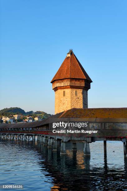 the famous wooden kapellbrücke spanning across the reuss river at sunset, in the city of lucerne. - chapel bridge stock pictures, royalty-free photos & images