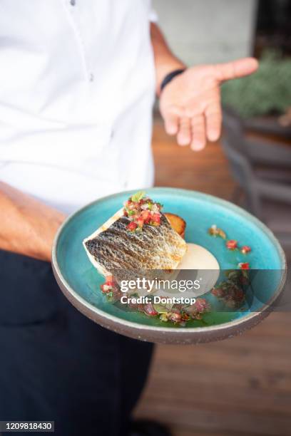 dish of slices fish with greens, lemon and onion on plate. - cod dinner stock pictures, royalty-free photos & images