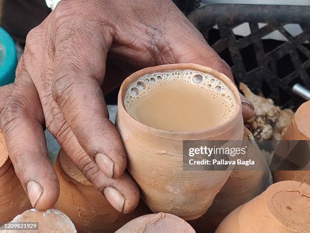 a earthen ware cup with tea. an earthy way to make tea india using earthen ware cups - chai tea stock pictures, royalty-free photos & images