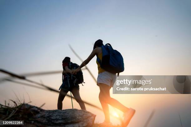 two young asian female hipster hiking on mountain holiday, wild adventure. background for travel concept . - berg klimmen team stockfoto's en -beelden