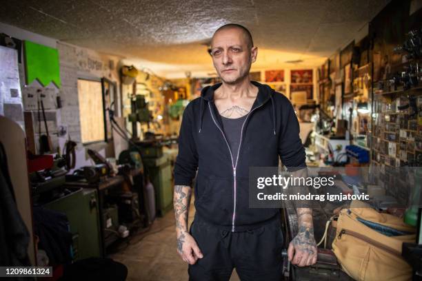 tattoo artist standing proudly in his workshop - one mature man only stock pictures, royalty-free photos & images