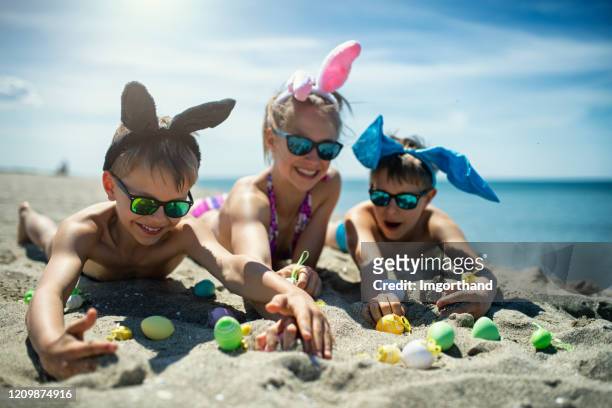crianças brincando na praia com ovos de páscoa - easter family - fotografias e filmes do acervo
