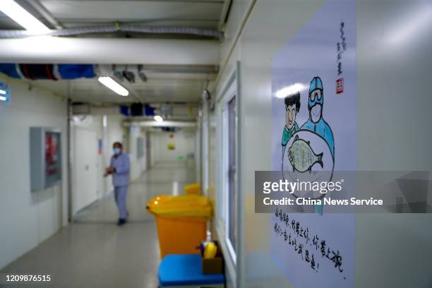 Caricature painting depicting patient and medical worker hangs on the wall at the Huoshenshan makeshift hospital on March 2, 2020 in Wuhan, Hubei...