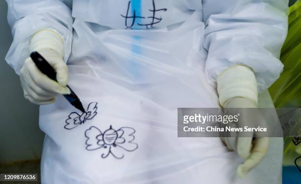 Medical worker paints butterflies on her protective suit at the Huoshenshan makeshift hospital on March 2, 2020 in Wuhan, Hubei Province of China.