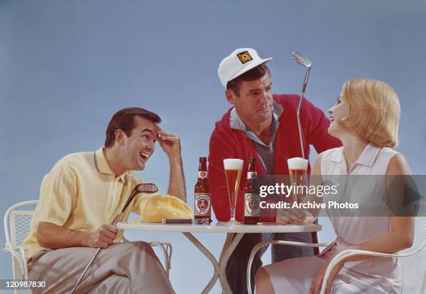 Friends having drink at table, smiling