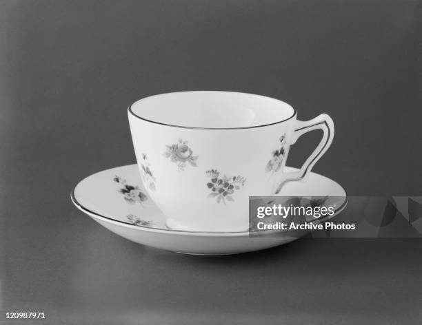 Cup and saucer on grey background, close-up