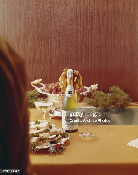 Tray sandwiches and champagne bottle on table