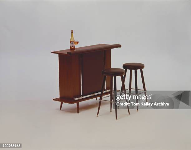 beer bottle and glasses on wooden table beside wooden stools - 1973 stock pictures, royalty-free photos & images