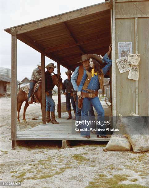 Cowboys and cowgirl standing outside saloon