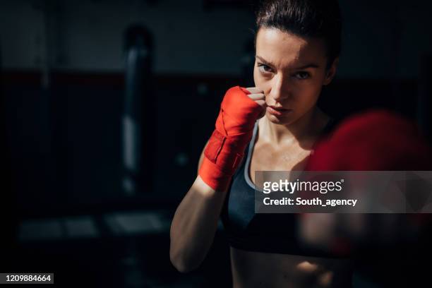 portrait of beautiful kick  boxer exercising in the gym - desporto de combate imagens e fotografias de stock