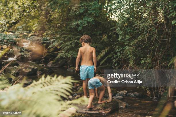 jungen spielen im fluss - boy in swimwear stock-fotos und bilder