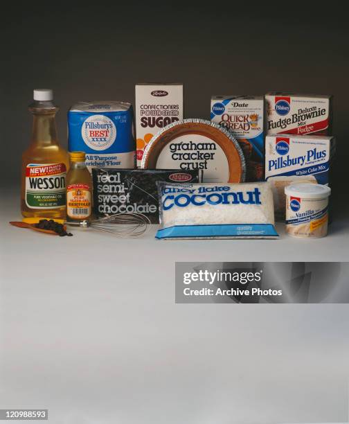 Carton food, oil, chocolate chips and wire whisk on white background