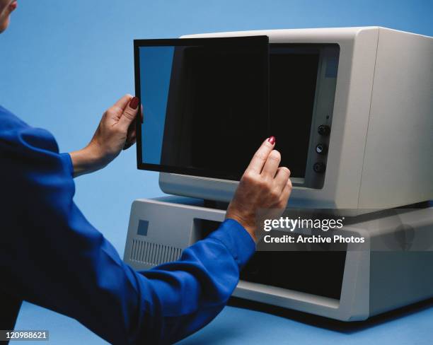 Woman placing computer screen on computer