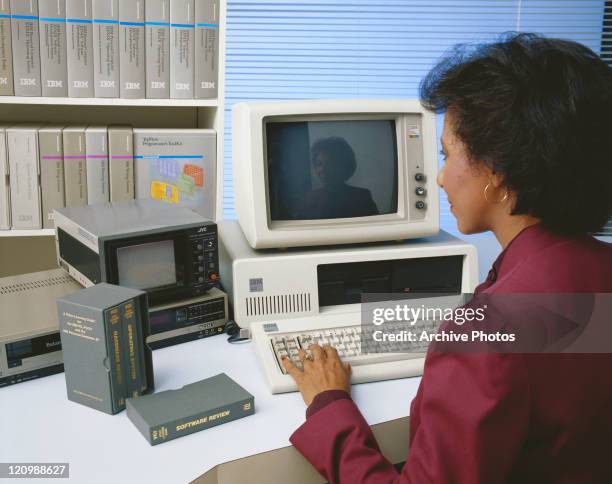 Mid adult woman working on old computer and watching video