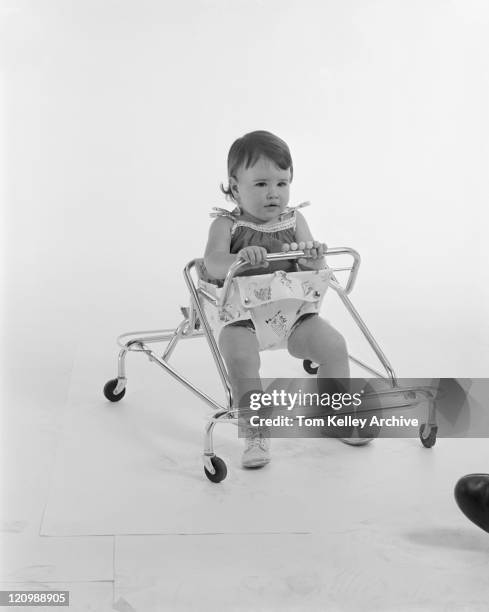 baby girl sitting in baby walker - baby walker stock pictures, royalty-free photos & images