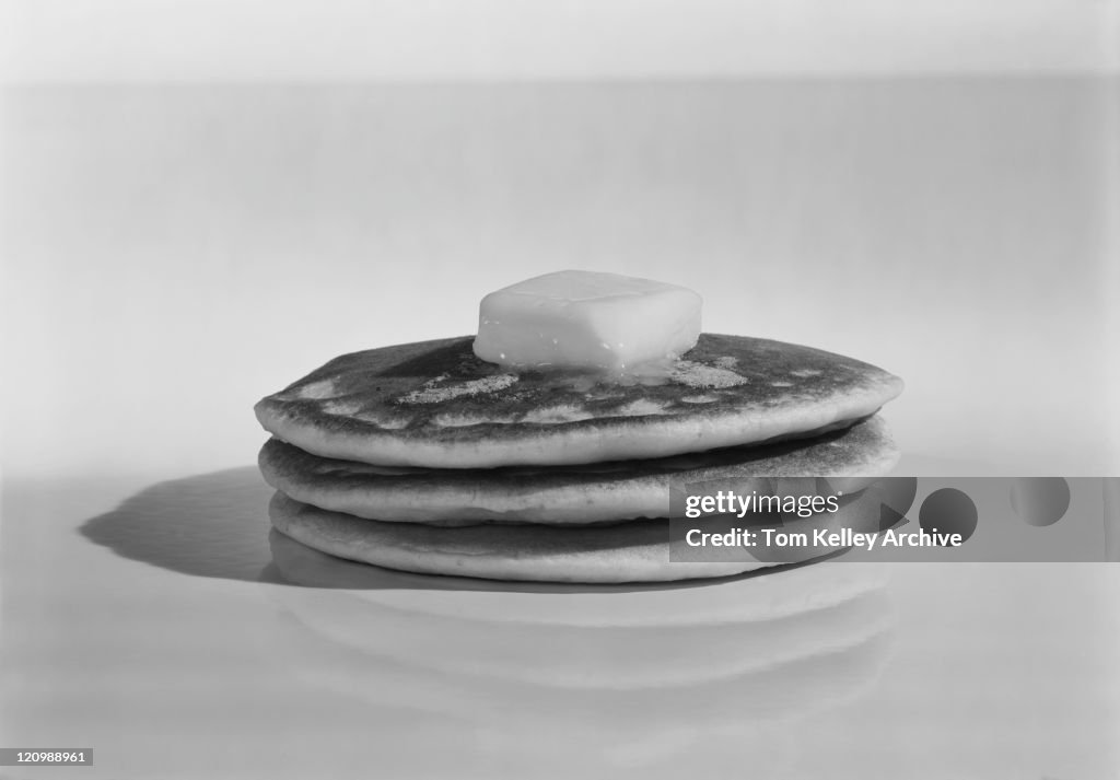 Pancakes with melting butter on white background