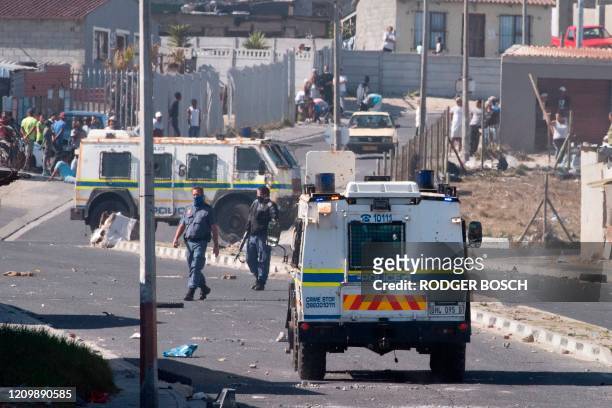 Members of the South African Police services clash with residents of Tafelsig, an impoverished suburb in Mitchells Plain, near Cape Town, on April 14...