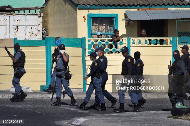 Members of the South African Police patrol the street during clashes with residents of Tafelsig, an impoverished suburb in Mitchells Plain, near Cape...