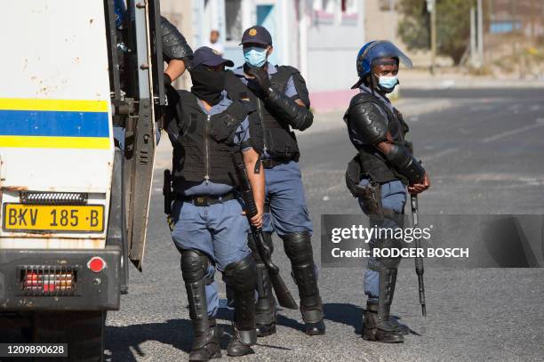 Members of the South African Police patrol the street during clashes with residents of Tafelsig, an impoverished suburb in Mitchells Plain, near Cape...