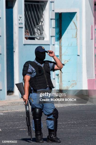 Member of the South African Police patrols the street during clashes with residents of Tafelsig, an impoverished suburb in Mitchells Plain, near Cape...