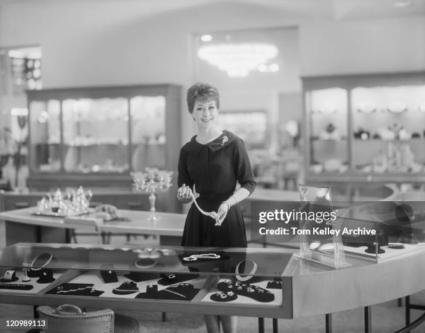 shop assistance holding necklace in jewellery shop, portrait - archival 1960s stock pictures, royalty-free photos & images