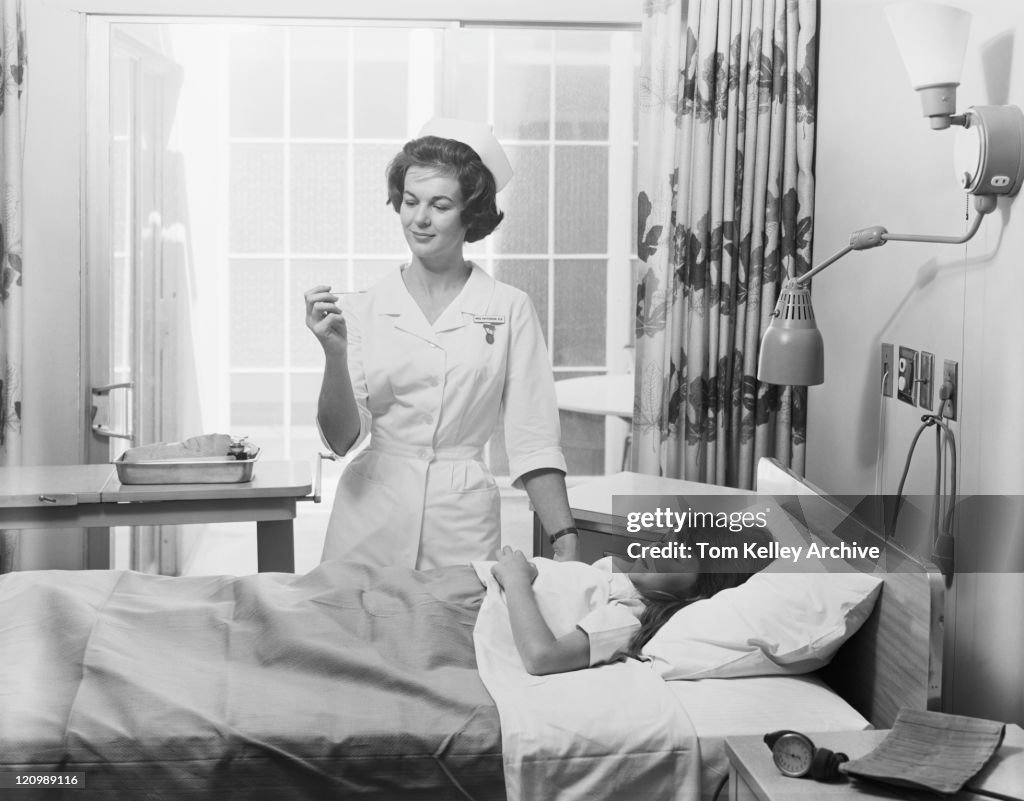 Female nurse checking girl's temperature