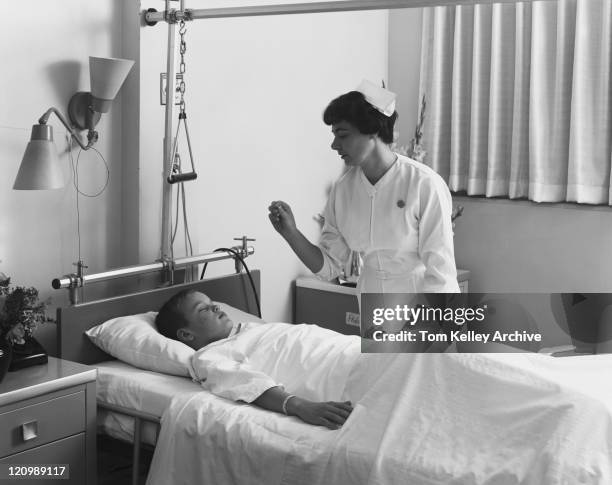 female nurse checking boy's temperature - 20th century stock pictures, royalty-free photos & images