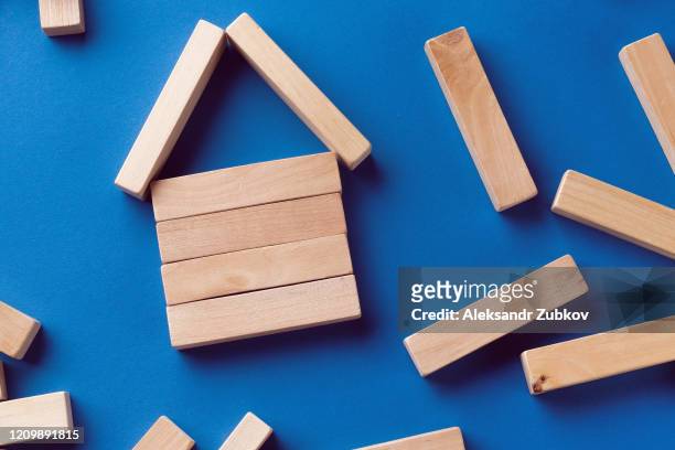 a pile of scattered wooden blocks on a blue background. construction game. the broken tower. - jenga stockfoto's en -beelden