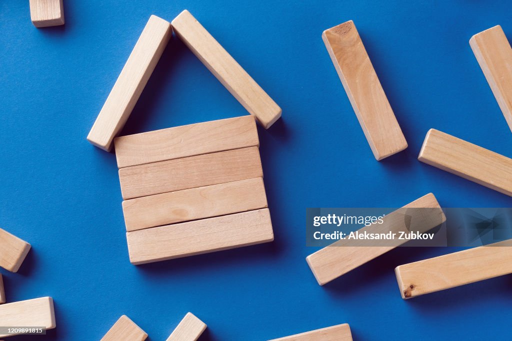 A Pile Of Scattered Wooden Blocks On A Blue Background. Construction Game. The broken tower.