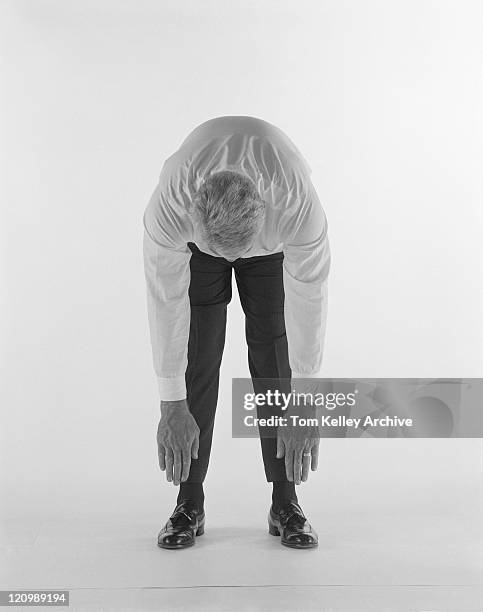 mature man bending over against white background - bending over stock pictures, royalty-free photos & images