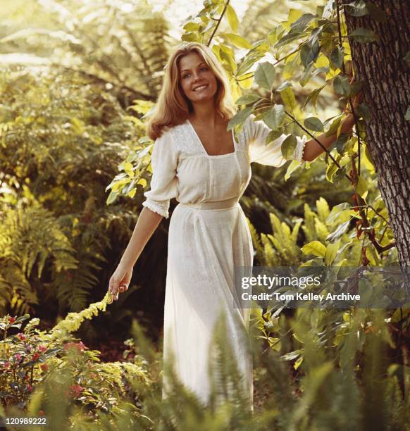 young woman standing in forest, smiling - 1974 stock pictures, royalty-free photos & images