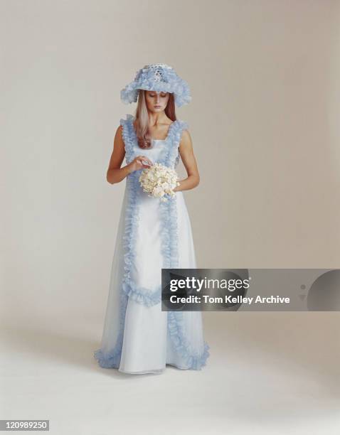 woman holding bouquet standing on white background - 1975 - fotografias e filmes do acervo