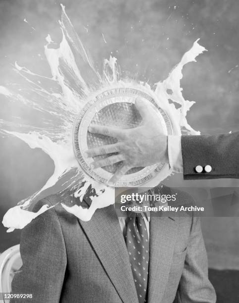 man smashing cake on other man's face - folly stock pictures, royalty-free photos & images