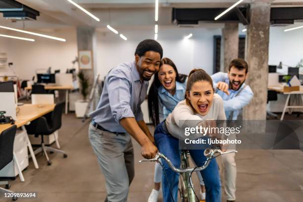 happy colleagues laughing in the office - business hero stock pictures, royalty-free photos & images