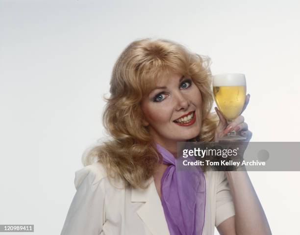 giovane donna con un bicchiere di birra, sorridente, verticale - anno 1980 foto e immagini stock