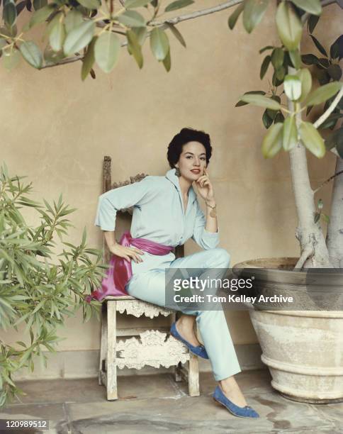 frau sitzt auf stuhl am großen topf plant, porträt - 1950 1959 stock-fotos und bilder