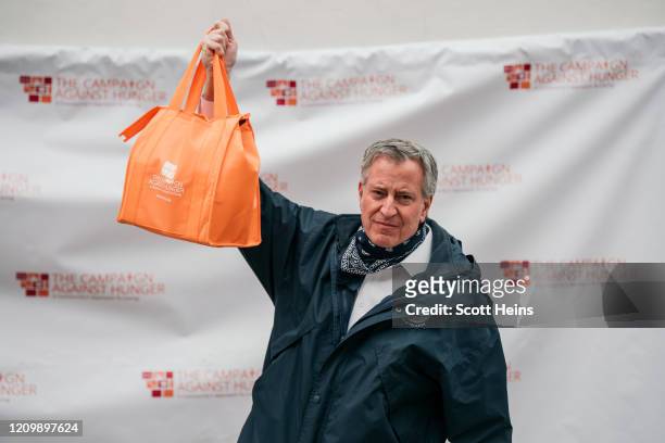 New York City Mayor Bill de Blasio holds a bag of produce packed at a food shelf organized by The Campaign Against Hunger in Bed Stuy, Brooklyn on...