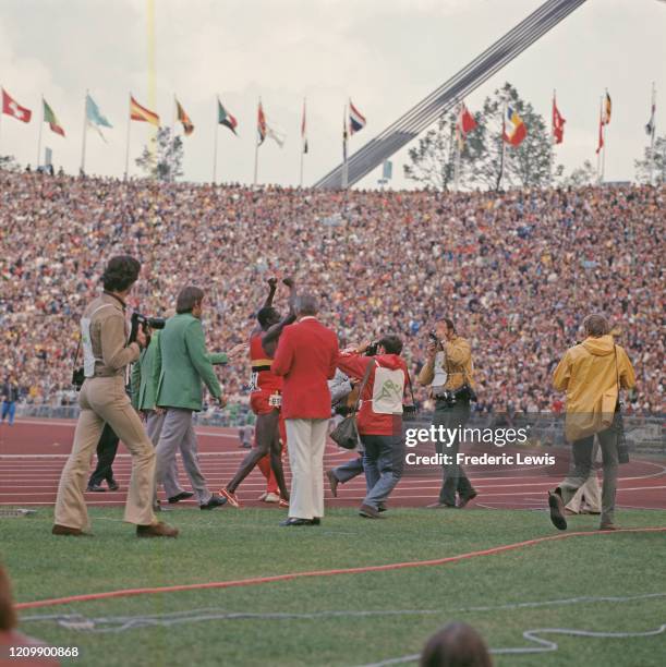 Ugandan hurdler, John Akii-Bua surrounded by photographers at the Olympic Stadium after winning the Men's 400 Meters Hurdles at the Olympic Games in...