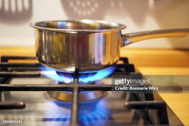 stainless steel pan on gas stove - gas cooking stock-fotos und bilder