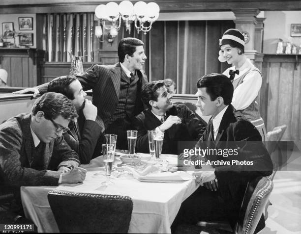 George Segal, David Doyle, Bert Convy, Jonathan Goldsmith, and George Hamilton sit around the table with drinks in a scene from the film 'Act One',...