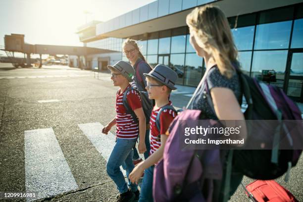 glückliche touristenfamilie zu fuß auf der landebahn - airfield stock-fotos und bilder