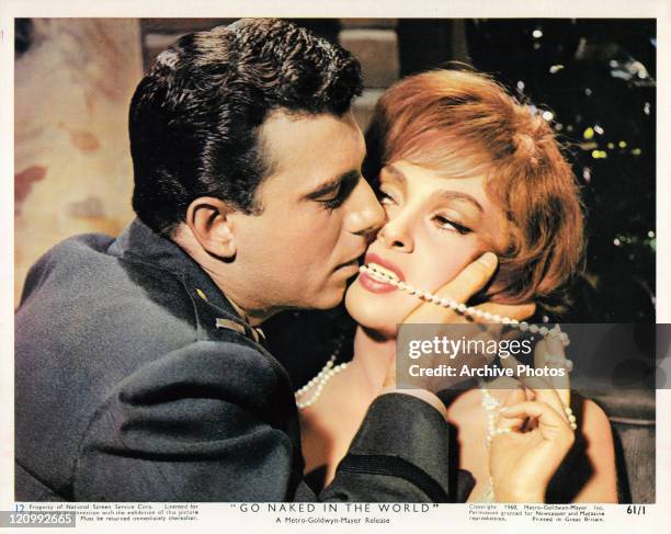 Anthony Franciosa kisses the face of Gina Lollobrigida who has a pearl necklace between her teeth in a scene from the film 'Go Naked In The World',...