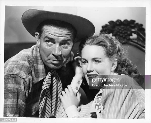 Bruce Cabot sitting close to Barbara Britton in a scene from the film 'Gunfighters', 1947.