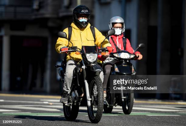 Motorcyclists ride the street with face protections on April 14, 2020 in Buenos Aires, Argentina. Since tomorrow, it will be obligatory to wear face...