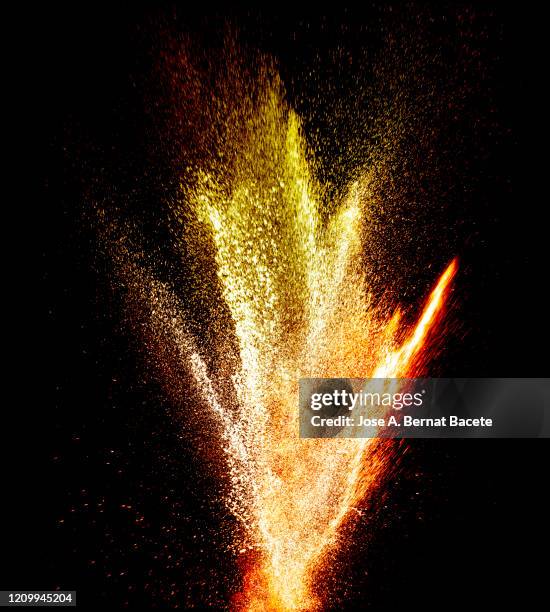 explosion by an impact of a cloud of particles of powder and smoke of color orange and yellow on a black background. - colourful studio shots stockfoto's en -beelden