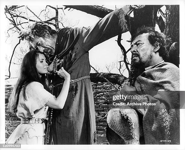 Anjanette Comer tries to comfort Anthony Quinn with Jose Chavez sitting nearby in a scene from the film 'Guns For San Sebastian', 1968.