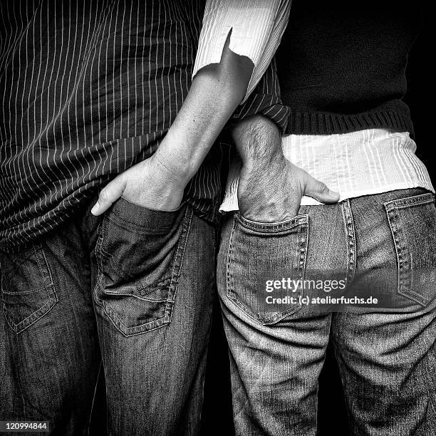 couple putting hands in each trousers back pocket - bolso traseiro imagens e fotografias de stock