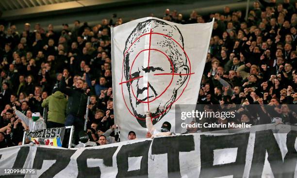 Supporters of Hannover 96 hold up a sign showing Dietmar Hopp of Hoffenheim in a crosshair during the Second Bundesliga match between Hannover 96 and...